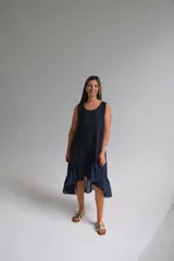 Vestido azul marino de lino italiano, sin mangas, con escote redondo y ruedo irregular con volados.