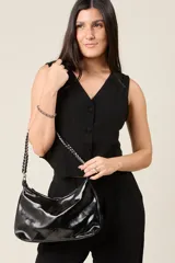 Cartera tipo baguette de ecocuero color negro, con correa de cadena metálica entrelazada.