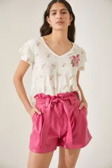 Remera de algodón pima color blanco con escote en V y volados en los hombros, decorada con un bordado de flor en tonos rosados.