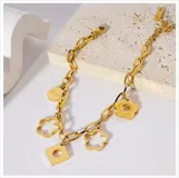 Pulsera dorada de acero quirúrgico con dijes colgantes de diferentes formas: flor maciza, flor calada, cuadrado calado y moneda con la palabra "Lucky".