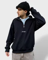 Buzo negro de felpa con frisa gruesa, corte boxy, medio cierre y estampado minimalista.