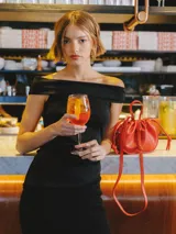 Top negro sin mangas con escote off-shoulder, detalle fruncido y calce ajustado.