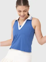 Top deportivo blanco con cuello polo y ribete verde oscuro.