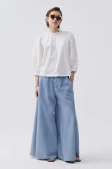 Blusa blanca con mangas abullonadas de bordado floral, y ajuste en las muñecas.