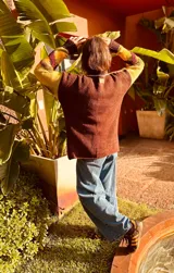 Sweater de punto color pistacho y marrón chocolate, con cuello alto y diseño geométrico bordado en el frente.