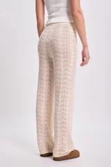Pantalón de punto crochet color crudo, de corte recto y cintura alta con cordón ajustable.