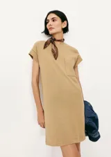 Vestido corto color crema, de corte recto y mangas cortas con bolsillo en el pecho.