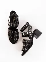 Sandalias de cuero color bordó con tres tiras horizontales sobre el empeine y pulsera al tobillo, ambas con apliques de tachas plateadas.