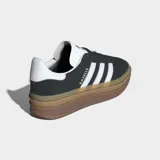 Championes Adidas Gazelle Bold negros con plataforma color caramelo y las tres tiras blancas a los costados.