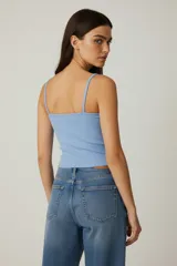 Musculosa blanca de algodón con breteles finos y estampado de una frutilla en el pecho. Corte al cuerpo.