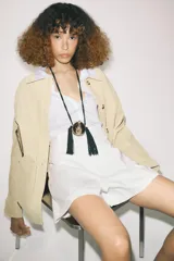 Shorts de tiro alto color negro, con cintura con trabillas, bolsillos laterales y cierre frontal con cremallera y ganchos metálicos.