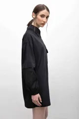 Remerón negro con cuello camisero gris, mangas largas grises con puños elásticos y bolsillo con solapa en el pecho.
