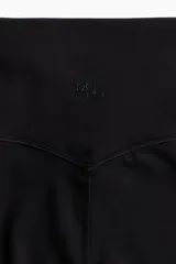 Calzas deportivas negras de tiro alto, confeccionadas en tejido funcional con tecnología SoftMove™ y DryMove™.