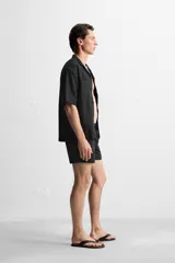 Short de baño negro de tejido técnico, con cintura elástica ajustable con cordón, bolsillos laterales y bolsillo trasero.