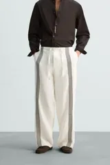 Pantalón de lino color crudo con rayas verticales negras, corte relaxed fit, cintura elástica ajustable con cordón, bolsillos laterales y traseros.