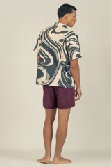 Camisa de manga corta con cuello tipo camp, con estampado abstracto en tonos beige y negro.