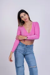 Remera corta gris de punto con escote cruzado y mangas largas.
