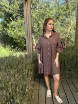 Vestido camisero azul de lino italiano, con cuello camisero, botones frontales, mangas 3/4 con doble volado y bolsillos laterales.