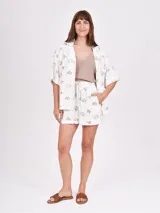 Camisa de manga corta con estampado de motivos playeros, como cangrejos, palmeras y sellos postales.