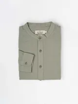 Camisa de manga larga color verde oliva, con cuello mao y cierre frontal con botones. Confeccionada en lino y poliéster.