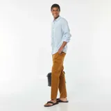 Camisa celeste de lino, de corte recto, con cuello clásico y mangas largas con puños abotonados.