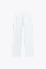 Jeans tobilleros de tiro alto color blanco, corte recto y bajo sin costura. Cierre frontal cruzado con cremallera y botones.