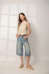 Chaleco color arena de cuero ovino, con cuello en V y cierre frontal con botones.