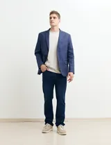 Saco azul de corte clásico con solapas de muesca, cierre de dos botones, bolsillo en el pecho y bolsillos laterales con solapa.