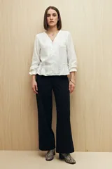 Pantalón de vestir color beige, de corte wide leg y tiro alto, con bolsillos laterales y traseros.