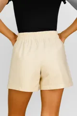Short color beige de lino y viscosa, con bolsillos laterales, cintura alta con elástico y corte holgado.