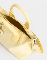 Cartera amarilla con doble asa corta de mano y correa regulable desmontable. Incluye charm colgante de perlas y cierre superior.