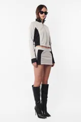 Campera deportiva negra con recortes grises en mangas y laterales. Cierre frontal y calce slim fit. Estampa de logo a tono en el recorte delantero.