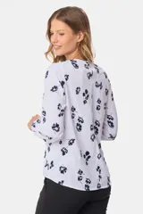 Blusa de manga larga con estampado floral sobre fondo blanco, ajuste cómodo y clásico.