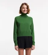 Blusa de punto color blanco, con cuello alto, manga larga y diseño liso.