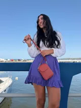 Bandolera pequeña y compacta de símil cuero color terracota, con correa ajustable del mismo material. Cuenta con cierre principal y bolsillo frontal con tapa y broche metálico.