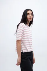 Remera holgada a rayas horizontales color crudo y beige, con mangas cortas y tajos laterales.