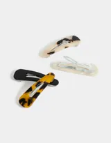 Set de cuatro hebillas para el pelo tipo tic tac, con diseños carey en colores blanco, beige, amarillo y negro.