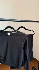 Remera negra de manga larga con cuello tipo bote, confeccionada en jersey térmico.