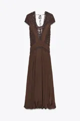 Vestido largo color marrón con detalle de crochet en el corpiño, escote redondo y manga corta. Cierre en la espalda con lazadas.