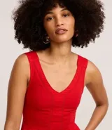 Mono largo rojo de sarga, con escote en V, sin mangas y detalle entrelazado en la cintura.