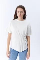 Remera blanca de manga corta con cuello redondo y pinzas laterales que crean un drapeado en la parte delantera.