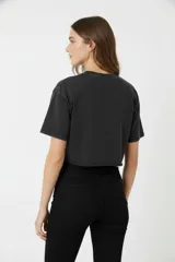 Remera cropped color borgoña de algodón, con cuello redondo y mangas cortas. Estampado frontal con un corazón sagrado con llamas, rosas y la leyenda 'Love Blooms'.