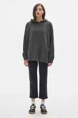 Buzo canguro color crudo, con capucha, mangas largas y bolsillo frontal.