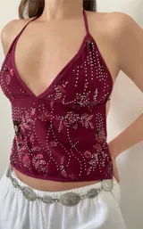Top bordó con escote halter, espalda descubierta y tiras finas ajustables.