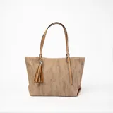 Bolso tote color marrón claro con textura tipo arpillera, doble asa fina color camel y detalle de borla decorativa.