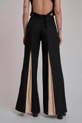 Pantalón ancho marrón con aberturas frontales que revelan un forro o panel interior de tela celeste. El pantalón se combina con un top a juego, creando un conjunto de dos piezas.