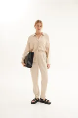 Pantalón de lino color beige, con cintura elastizada y cordón ajustable.
