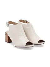 Sandalia peep toe color blanco hueso, confeccionada en cuero, con taco de madera y hebilla metálica.