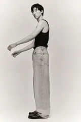 Pantalón jean gris claro, de corte holgado con pierna ancha y tiro bajo. Diseño clásico de cinco bolsillos con cierre frontal con cremallera y botón.