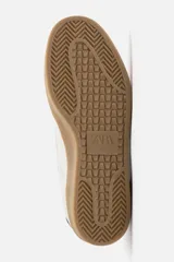 Zapatillas deportivas de estilo retro, color blanco con detalles en beige y negro. Capellada de cuero sintético con perforaciones laterales y puntera de gamuza. Suela de goma color caramelo.